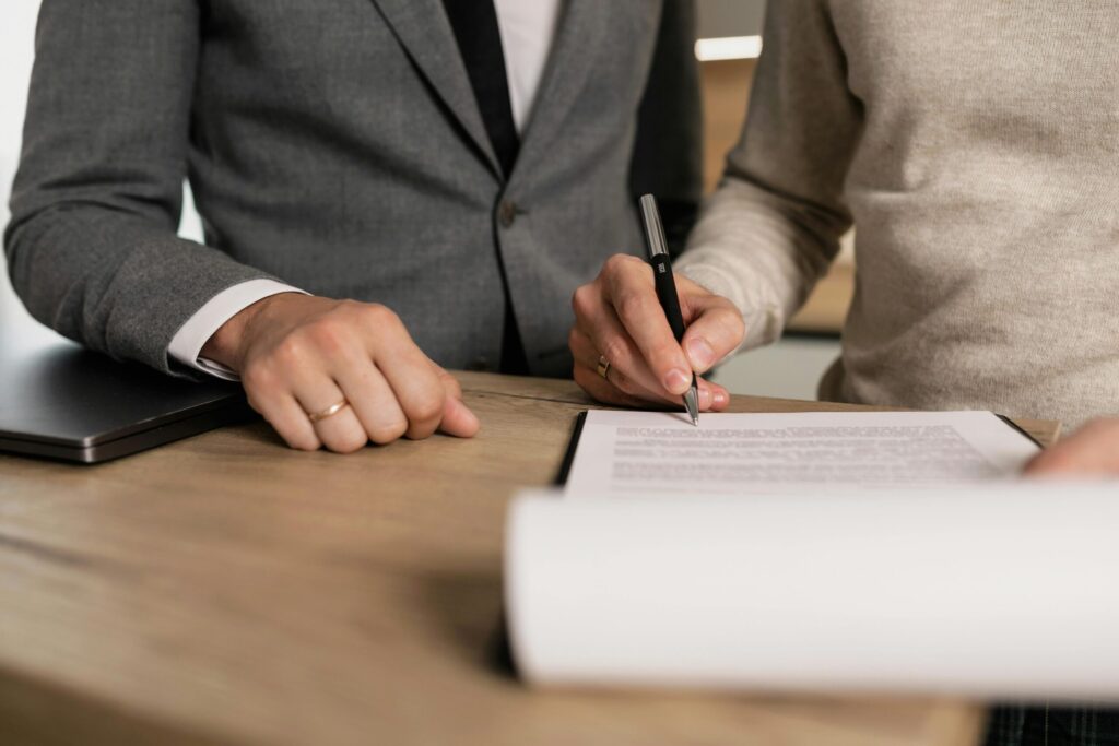 two people signing a contract