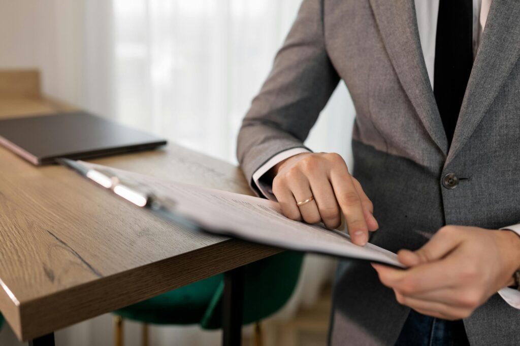 a person in gray suit holding a black clipboard